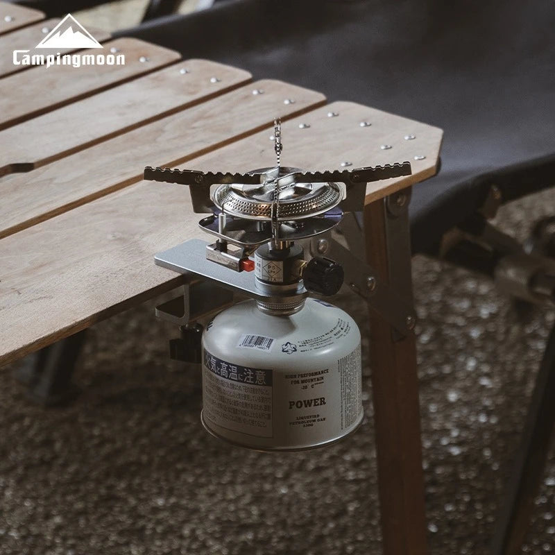 Camping stove with fuel canister on a wooden surface, brand 'Campingmoon' visible.