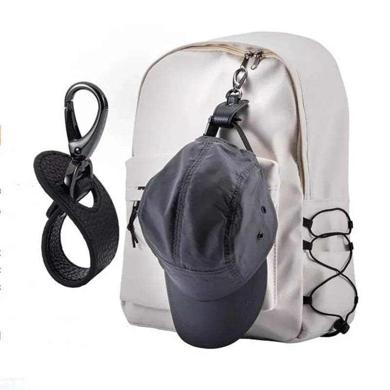 White backpack with a gray cap hanging out, black keychain on white background