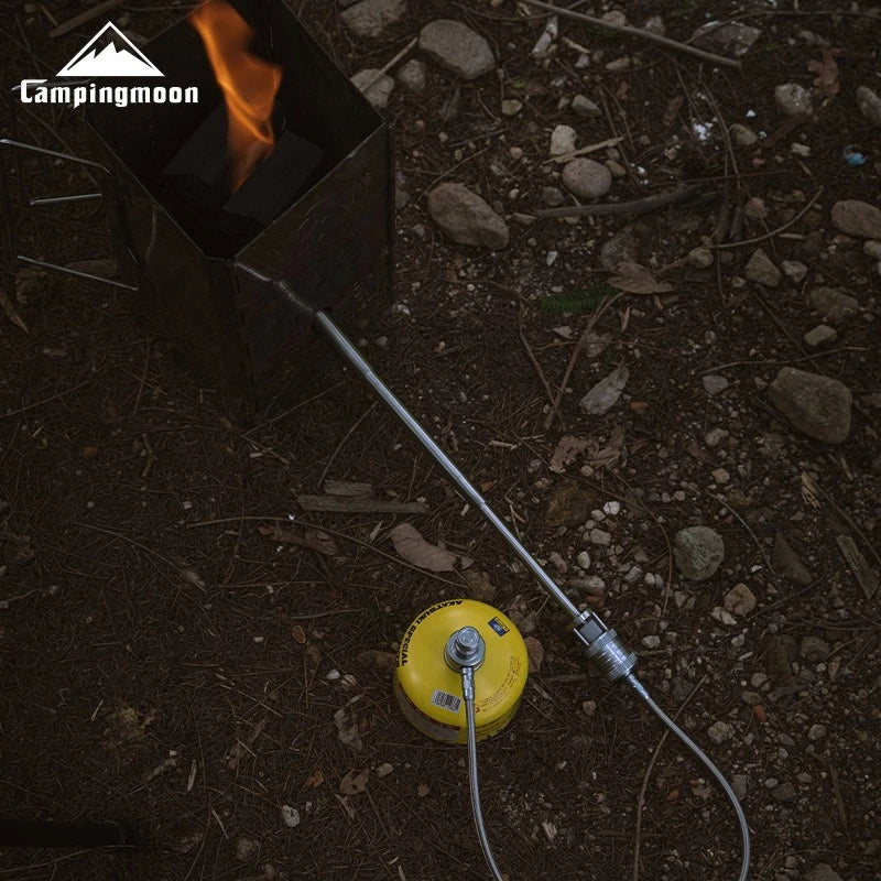 Camping stove with flame on a rocky ground, featuring the Campingmoon brand.