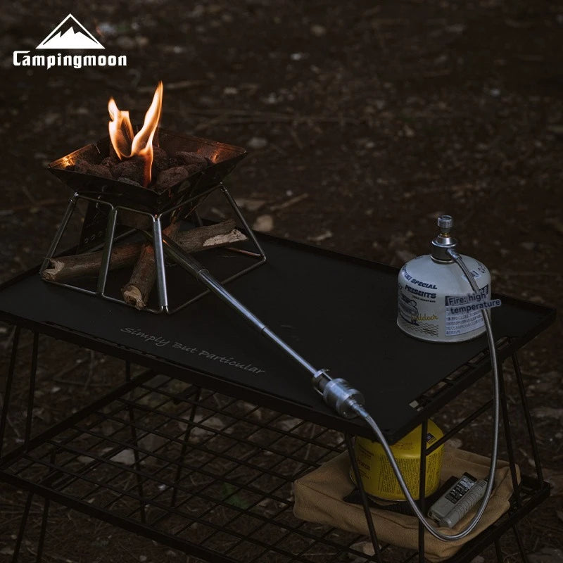 Camping stove with fire and gas canister on a black surface, featuring Campingmoon branding.