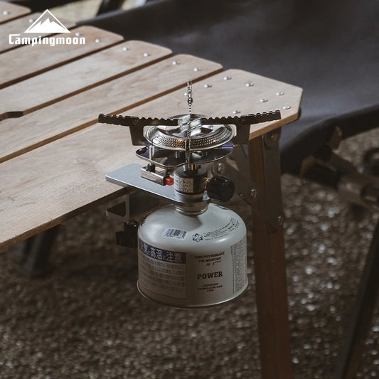 Camping stove with fuel canister on a wooden surface, brand 'Campingmoon' visible.