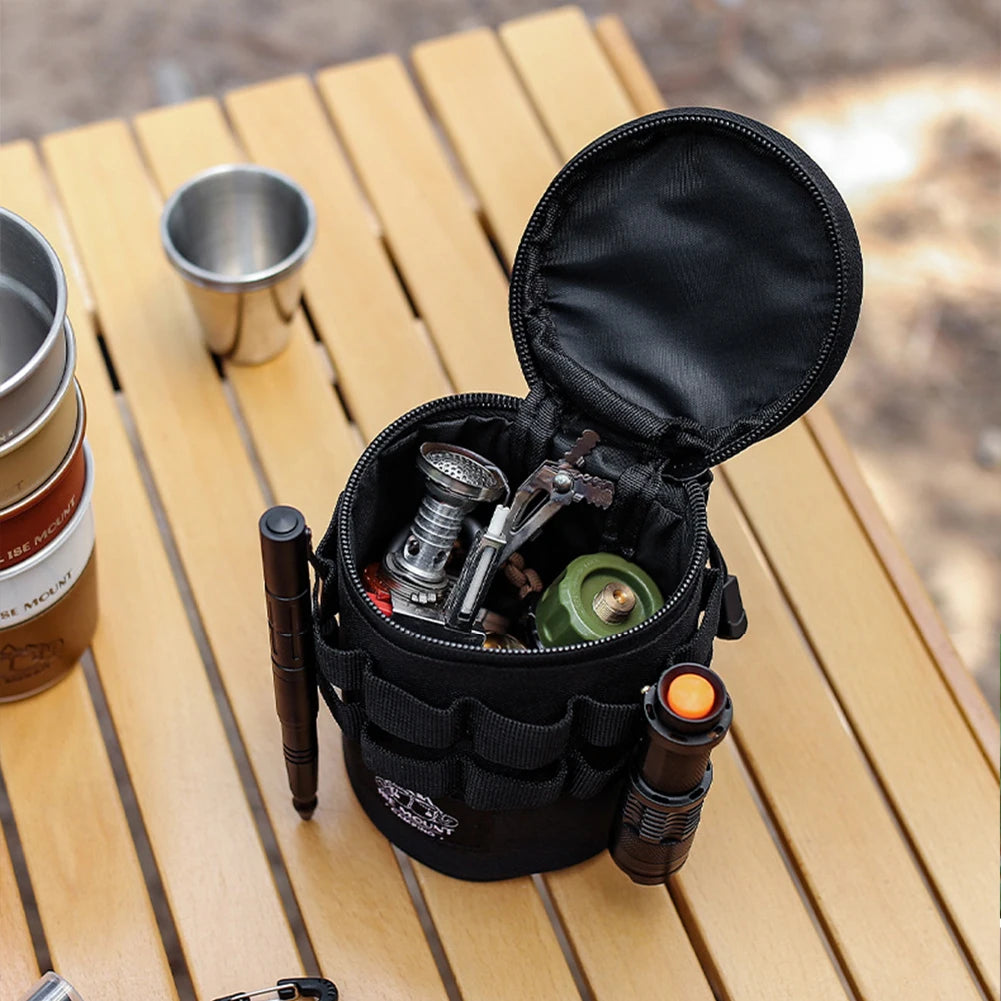 Black tool pouch with camping gear on a wooden surface