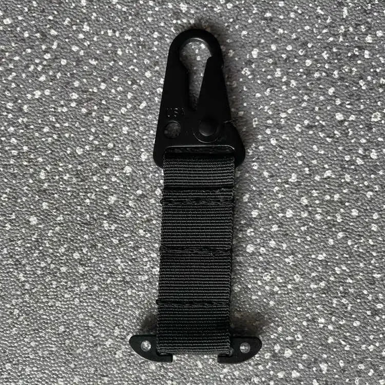 Black strap with clip on a textured gray background