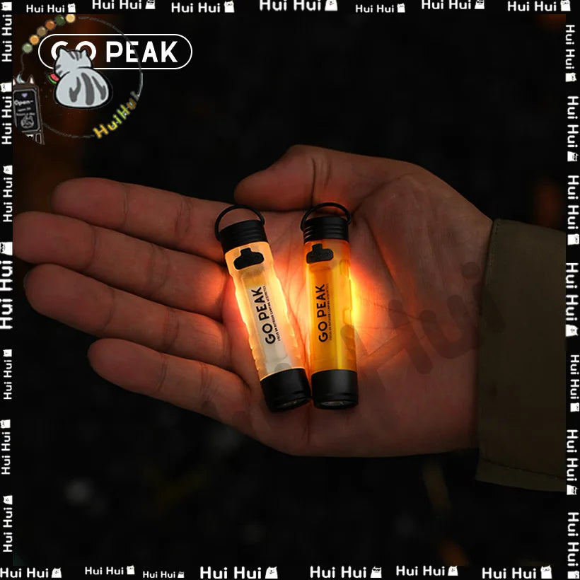 Two glowing 'GO PEAK' light sticks held in a hand with a dark background.