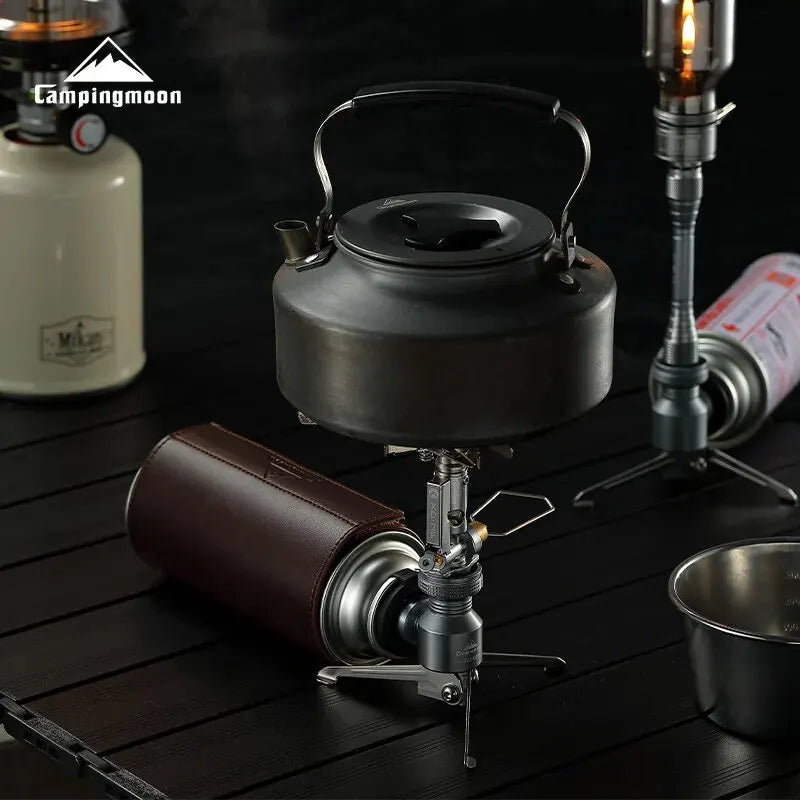 Camping stove with kettle and accessories on a dark surface, featuring the Campingmoon brand.