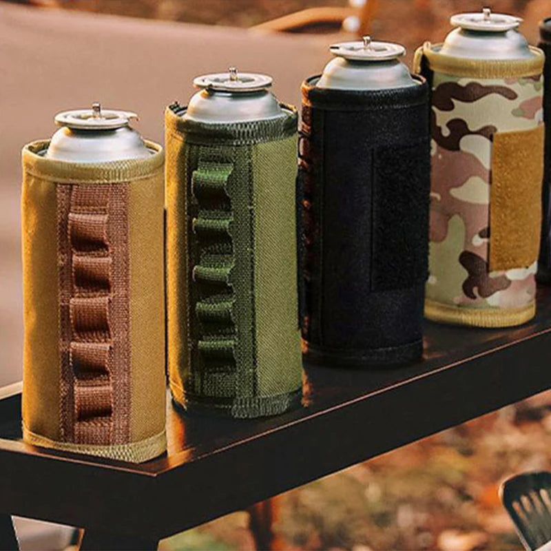 Four can coolers with different designs on a table outdoors.