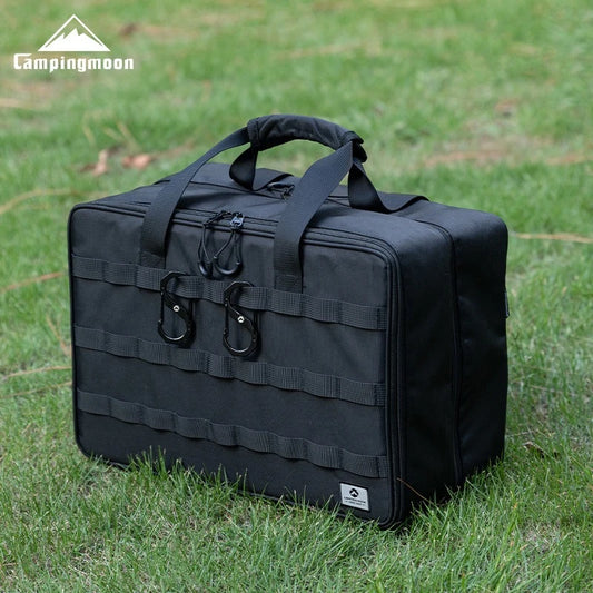 Black tactical bag on grass with Campingmoon logo