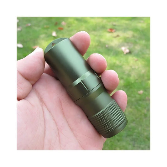 Green flashlight held in a hand with a blurred green background