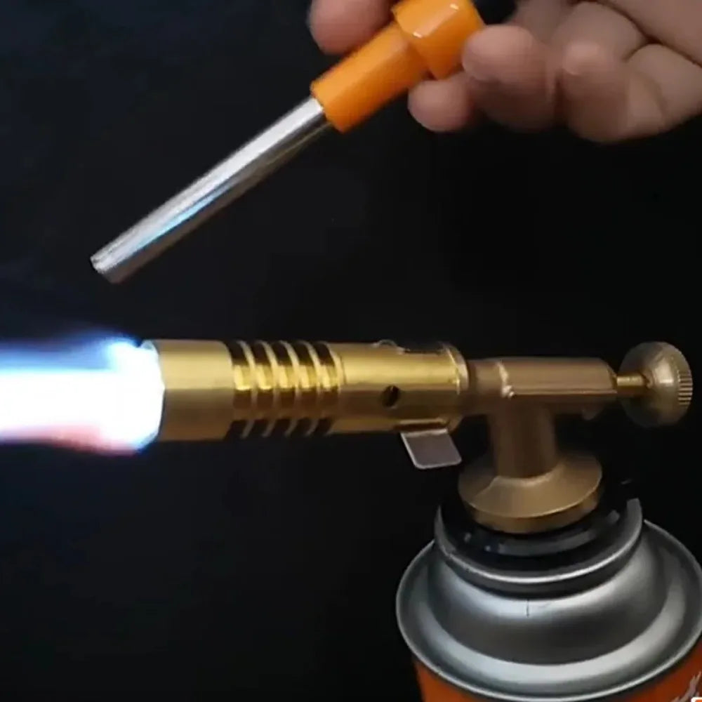 Butane torch with a flame being ignited against a dark background