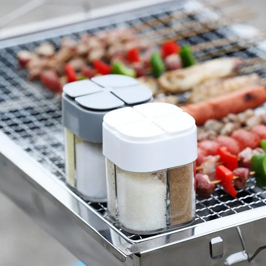 Spice shakers on a grill with skewered vegetables
