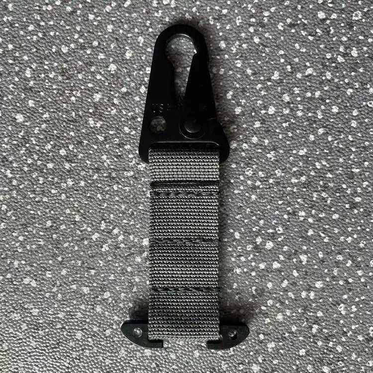Black carabiner with a textured strap on a gray speckled background