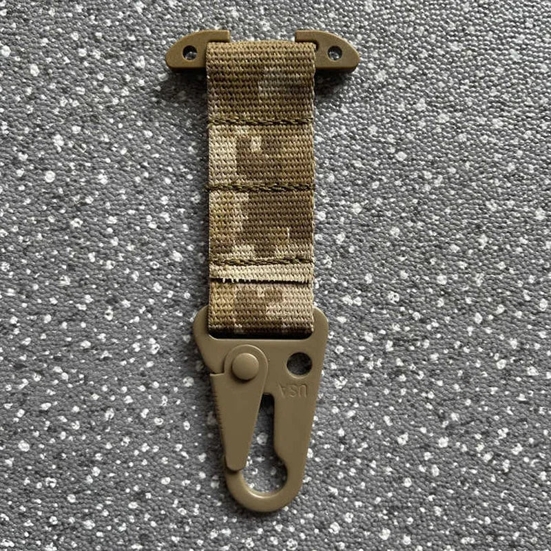 Tactical keychain with camouflage strap and metal clip on a gray background