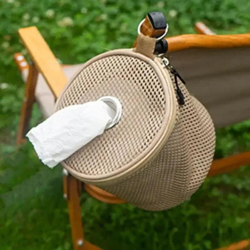 Round beige woven pouch with a white cloth on a wooden chair outdoors.